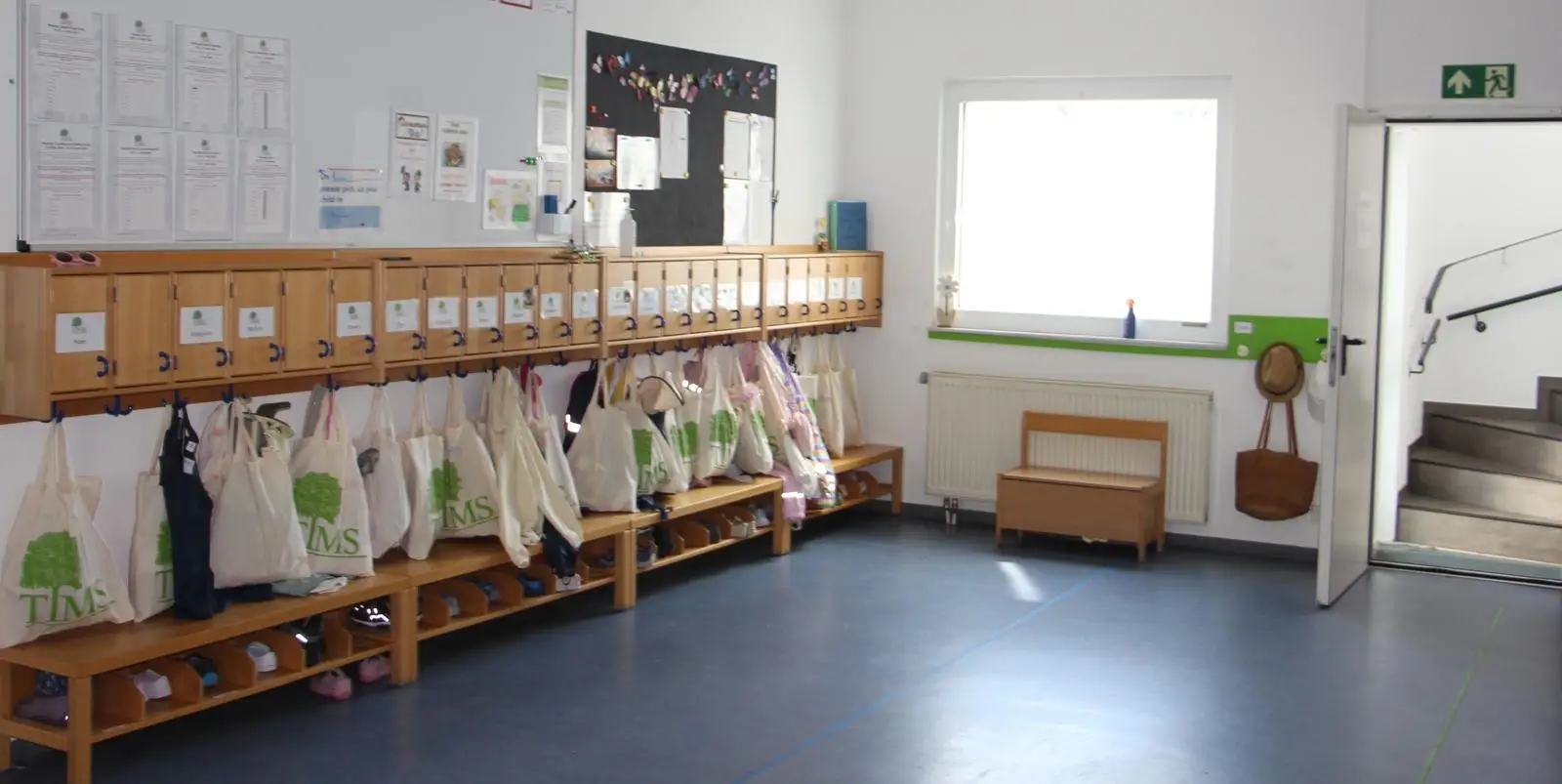 Cloakroom with labeled cubbies and TIMS tote bags for children's belongings