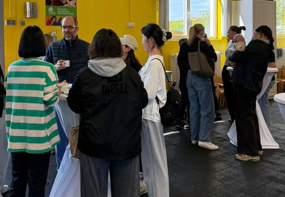 Parents and staff mingling at a TIMS community gathering event